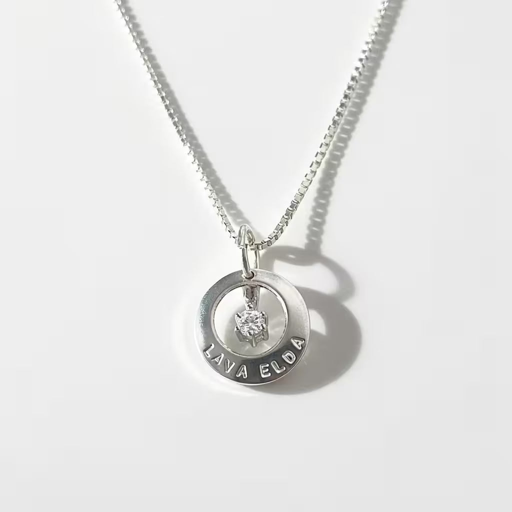 liten och snyggt halsband i äkta silver med ringformad namnbricka och en diamant i mitten. Namngravyr ingår
