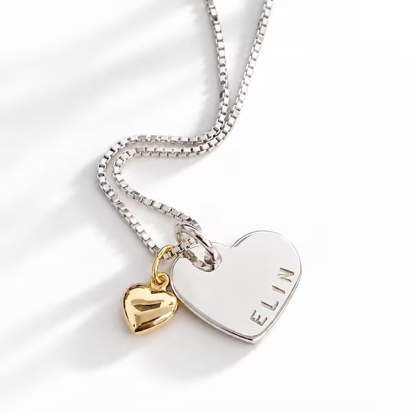 Silverhalsband med hjärtformad berlock med ett namn och ett guldhjärta vid sidan om