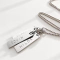 Handgjort silverhalsband med tre namnbrickor där varje bricka är prytt med ett namn. Kulkedja vackert
