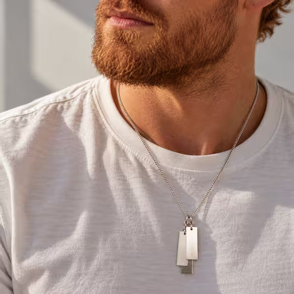 Man med silverhalsband med tre namnbrickor i äkta silver
