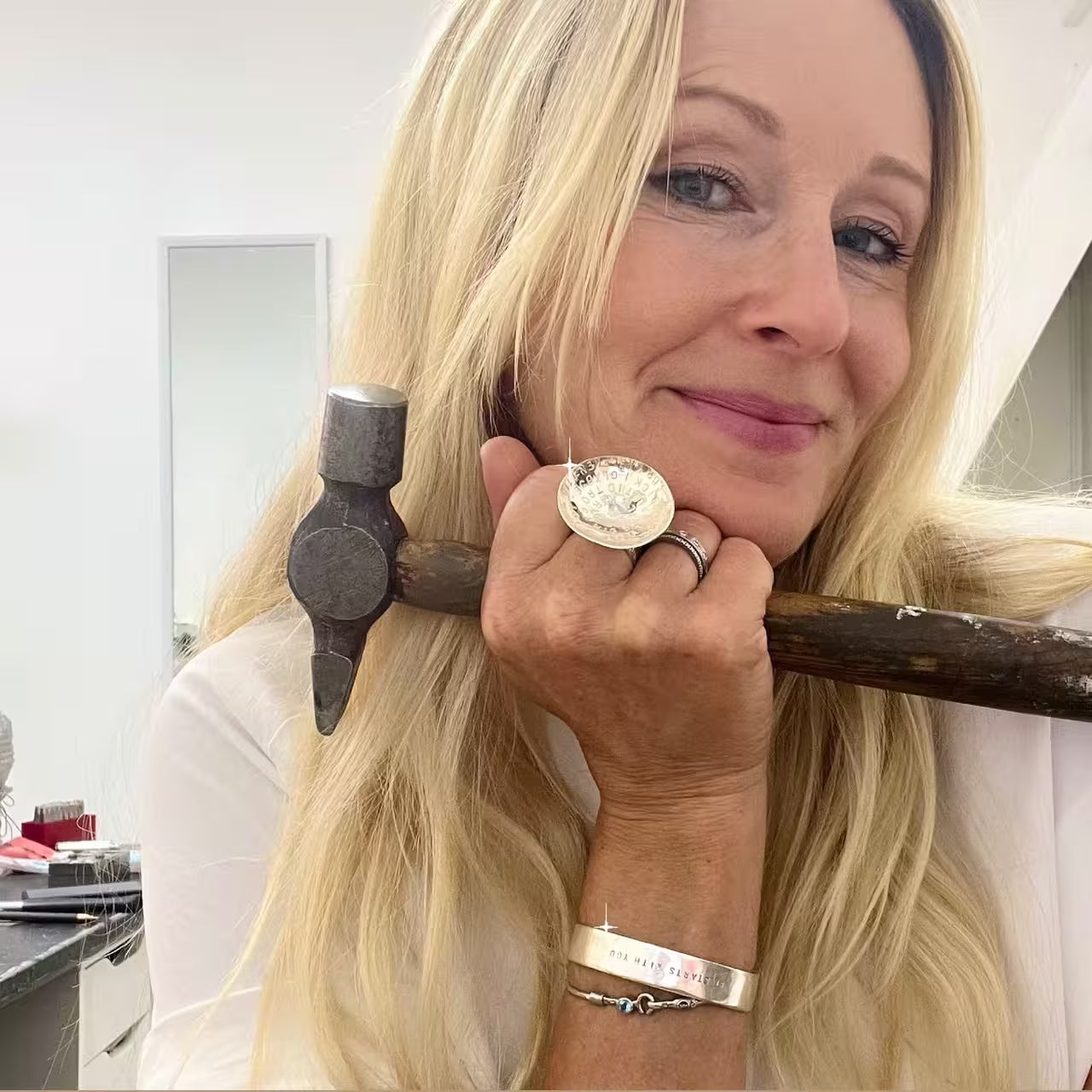 Silversmed Amanda Egilson i Stockholm med sin morfars gamla hammare och en ring med namn samt ett classic cuff armband med gravyr.