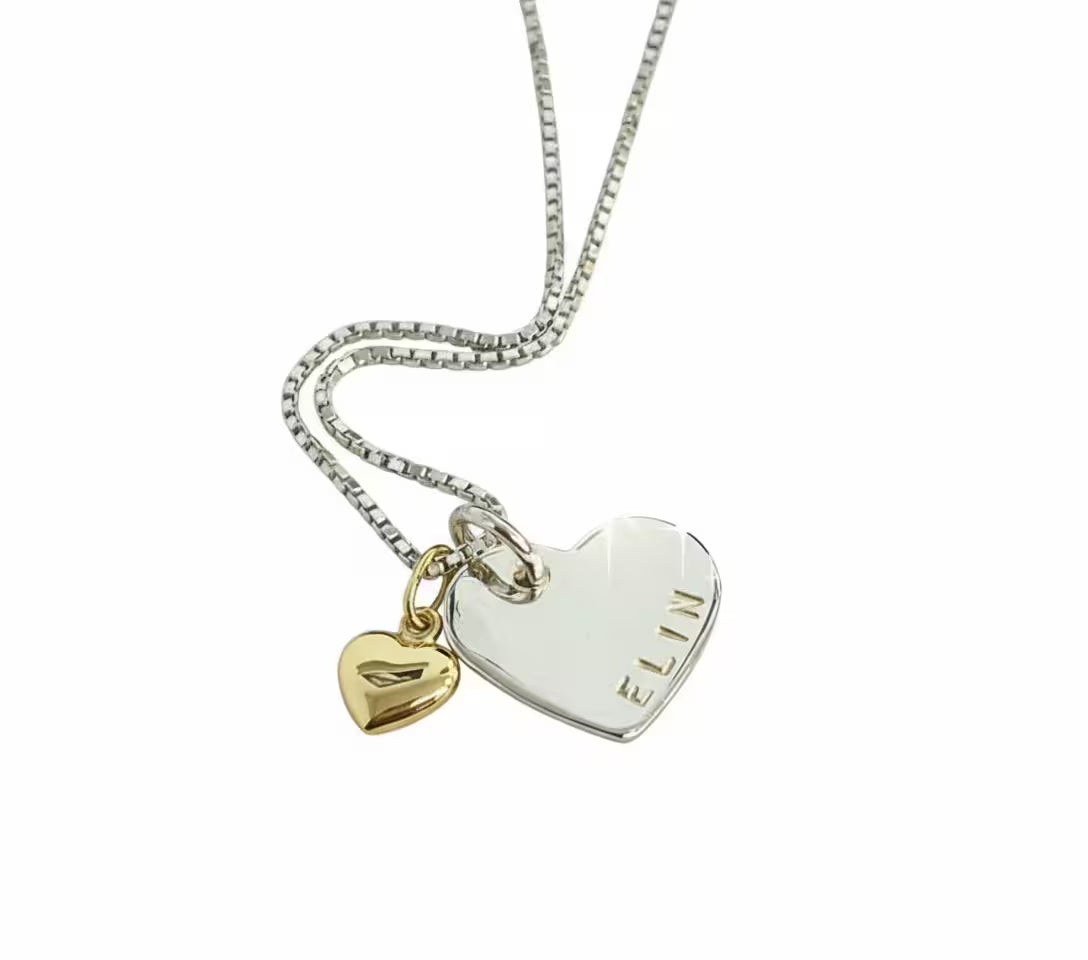 äkta silver halsband med hjärtformad namnbricka med personlig gravyr och ett 18k guldhjärta som dekoration bredvid
