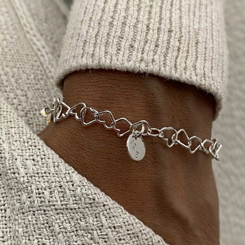 Lycka armband med namn armband med söt länk bestående av hjärtan hela vägen runt armen och med en liten rund bricka med namn gravyr