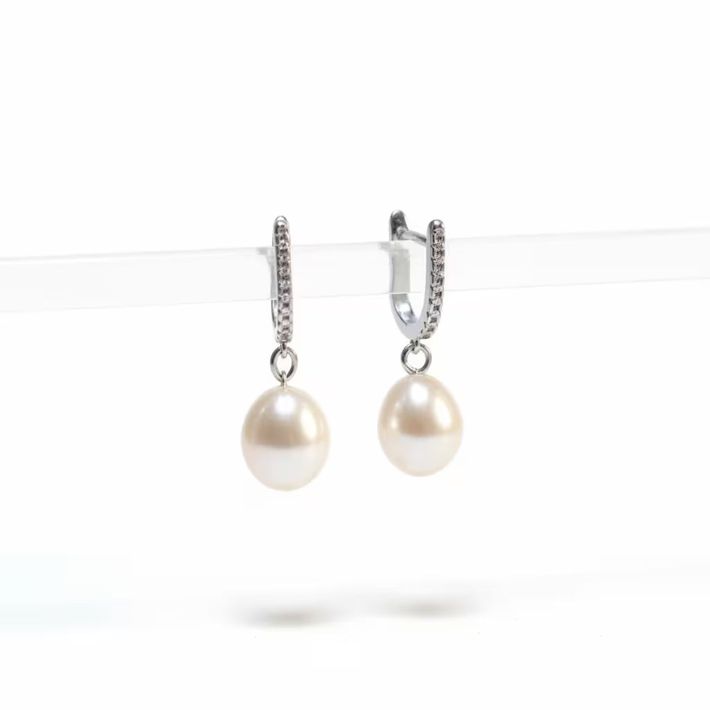 vackra örhängen med stor oval pärla och en glittrande creol som ring