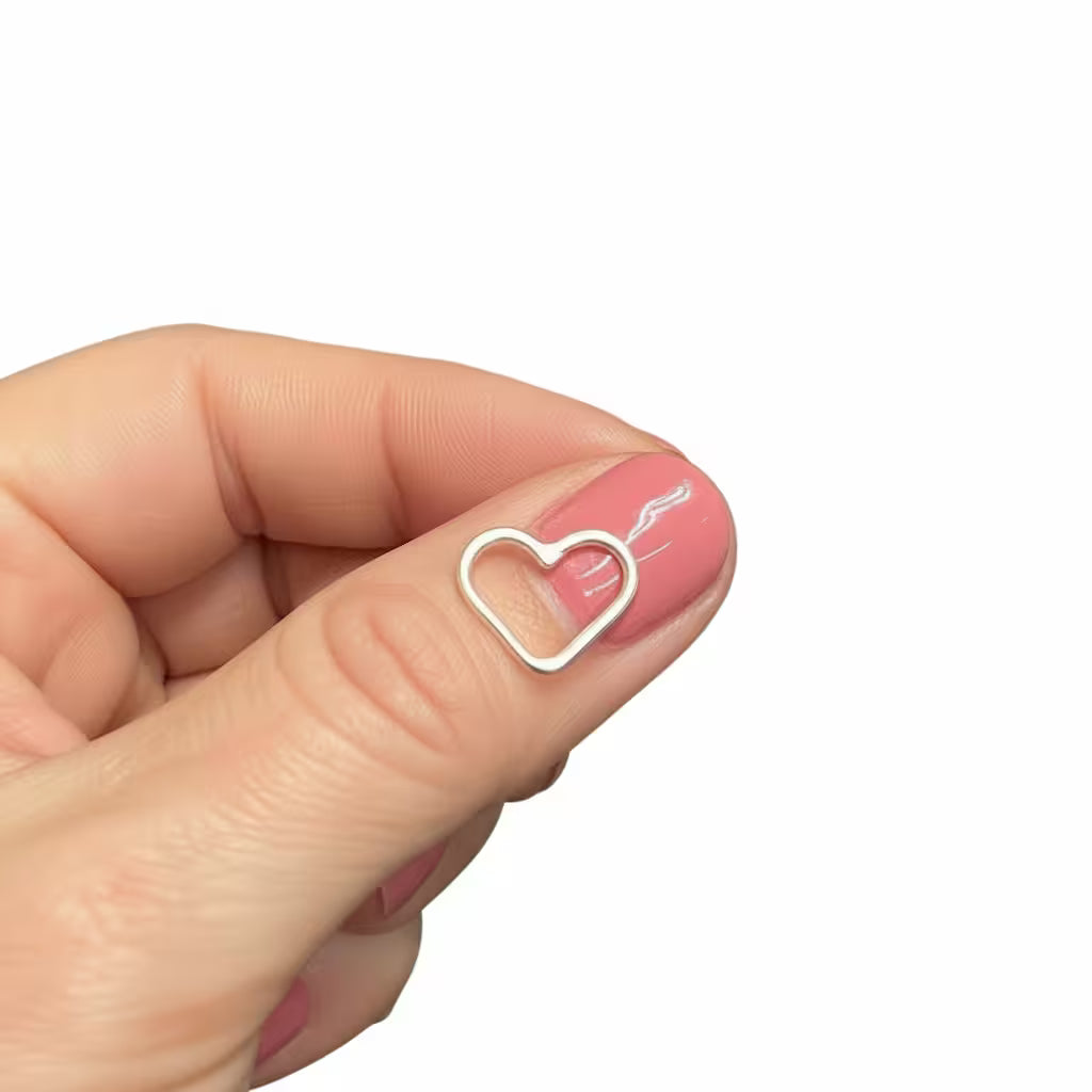 litet trådhjärta i äkta silver som är fint som tillbehör på ett silverhalsband eller armband